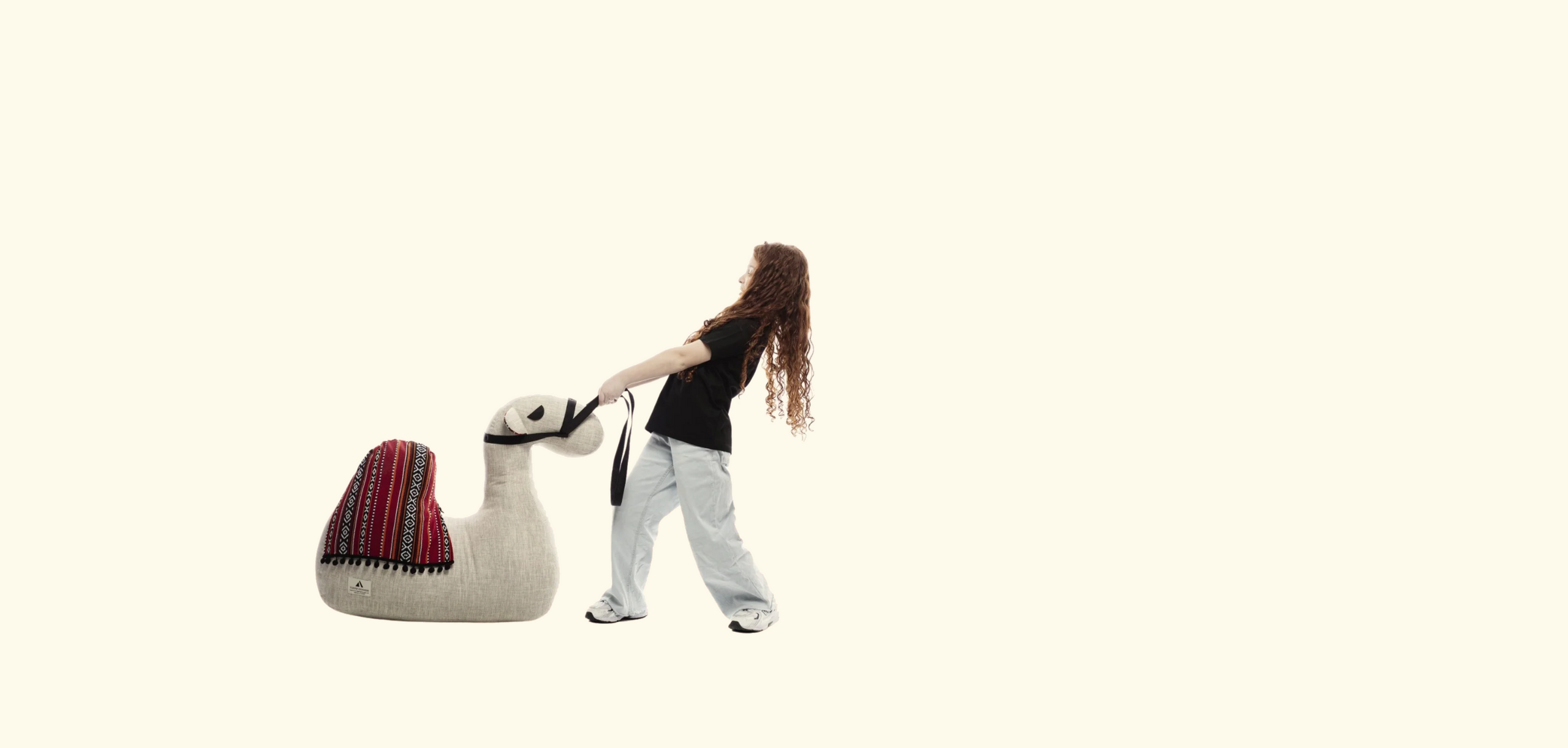 Person walking a large llama-shaped pillow on a white background