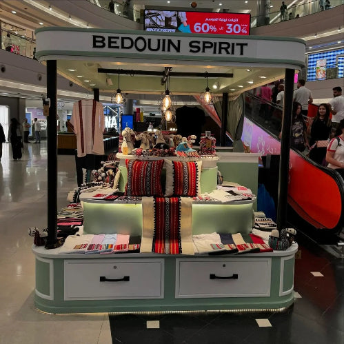 Bedouin Spirit display booth in a mall with promotional signs above.