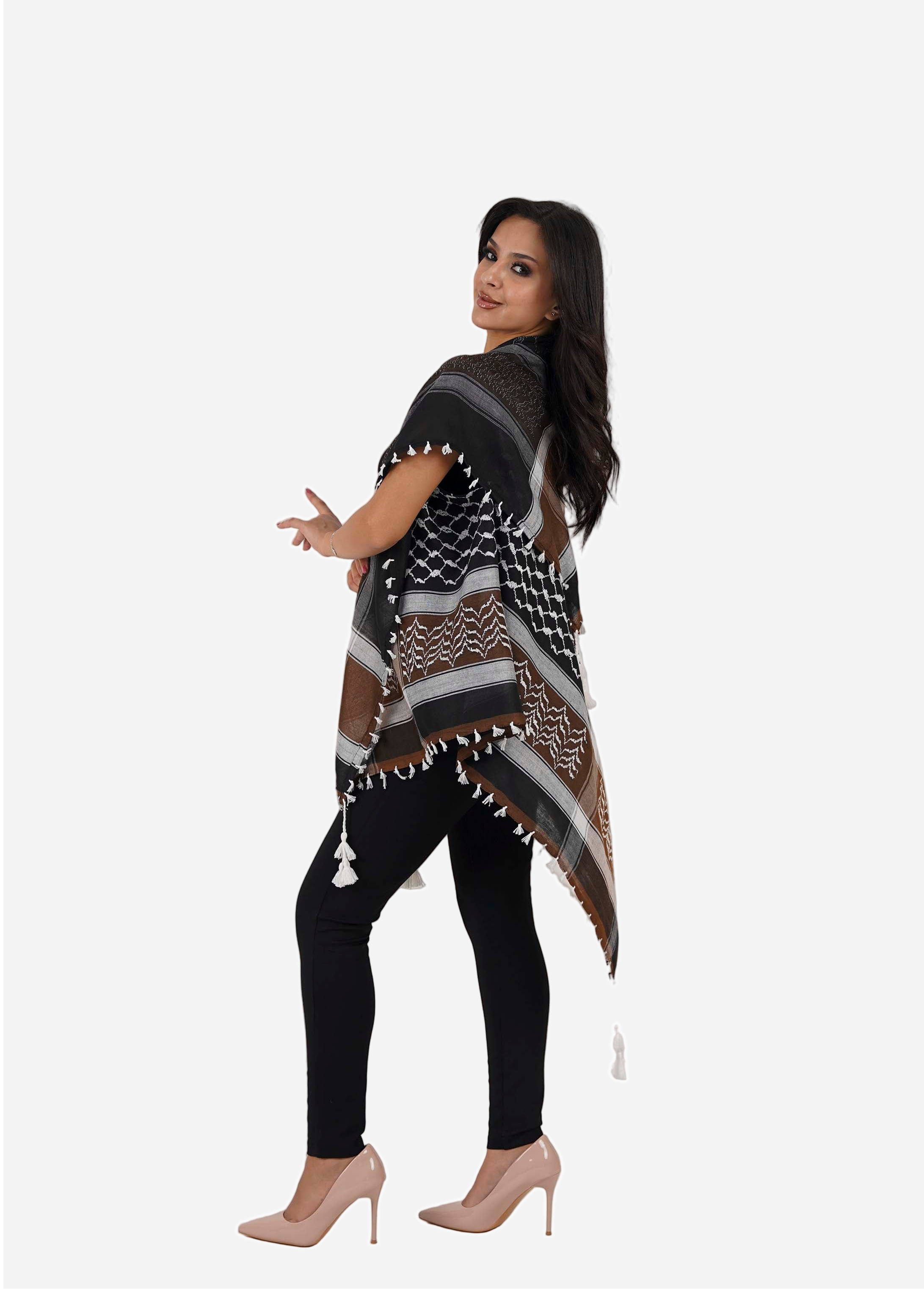 Woman wearing a patterned poncho and black leggings on a white background